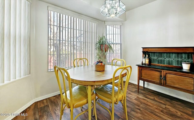 dining room with dark wood-type flooring and a notable chandelier