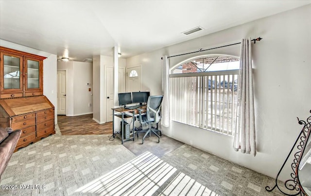 home office with visible vents and carpet flooring