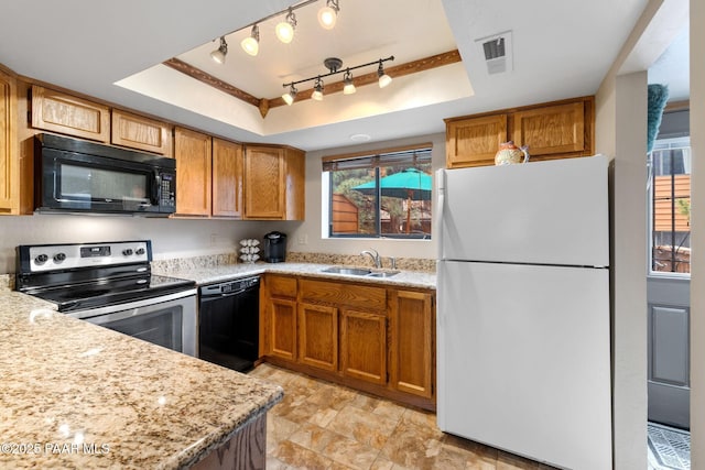 229 Creekside Cir Unit 15C, Prescott, AZ 86303 - kitchen featuring black appliances, a tray ceiling, a sink, and brown cabinets
