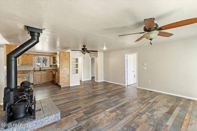 4820 S Lund Ct, Prescott, AZ 86303 - unfurnished living room with ceiling fan, a wood stove, dark wood finished floors, and a textured ceiling