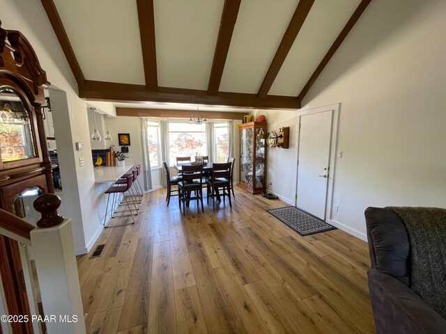 14600 E Eagle Dr, Dewey-Humboldt, AZ 86327 - dining area featuring a chandelier, beam ceiling, wood finished floors, baseboards, and high vaulted ceiling