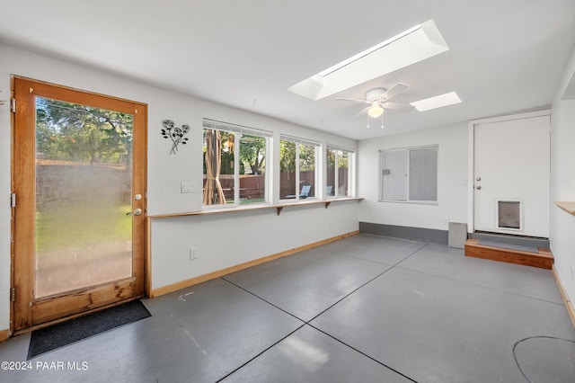 unfurnished sunroom with a skylight and ceiling fan