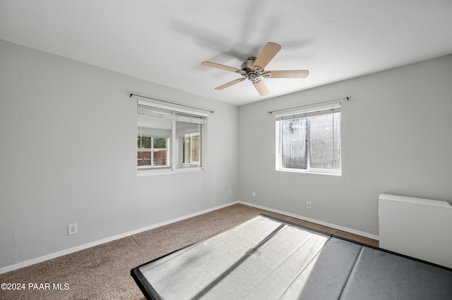 unfurnished room with carpet flooring, a wealth of natural light, and ceiling fan