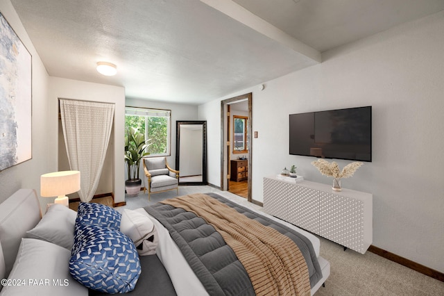 bedroom featuring light carpet and a textured ceiling