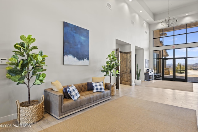 living area with a chandelier, visible vents, and wood finished floors