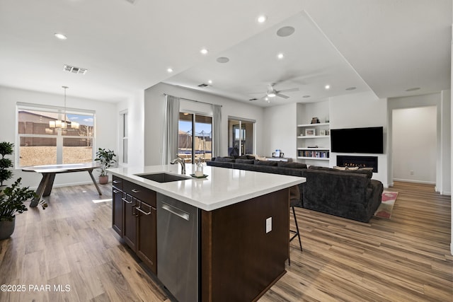 kitchen featuring dark brown cabinets, visible vents, light wood-style floors, and dishwasher