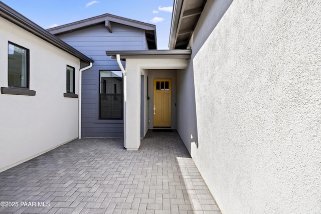 doorway to property with a patio area and stucco siding