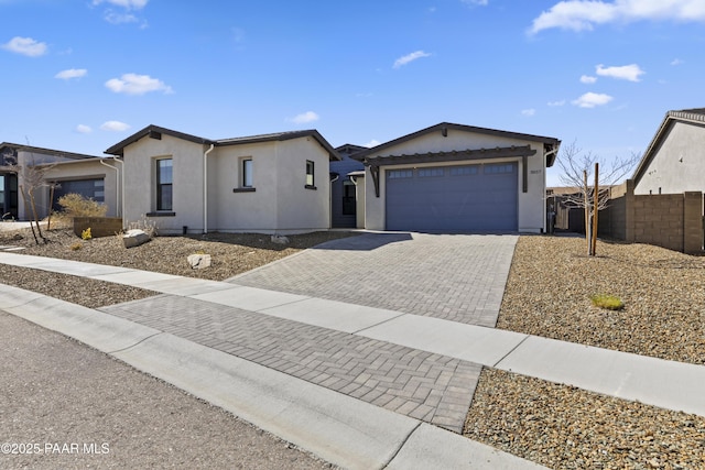 single story home with stucco siding, decorative driveway, a garage, and fence