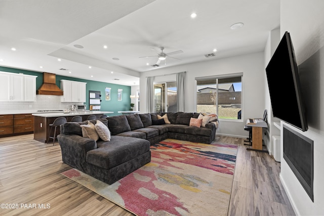 living room with recessed lighting, visible vents, and light wood-style floors