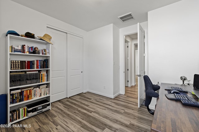 office with visible vents, baseboards, and wood finished floors