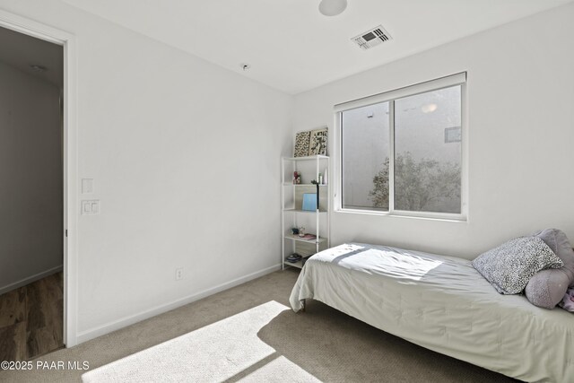 bedroom featuring visible vents, baseboards, and carpet