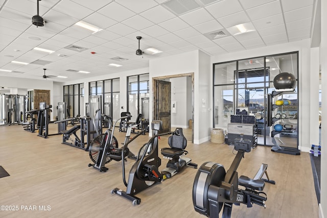 exercise room with visible vents, a paneled ceiling, and wood finished floors