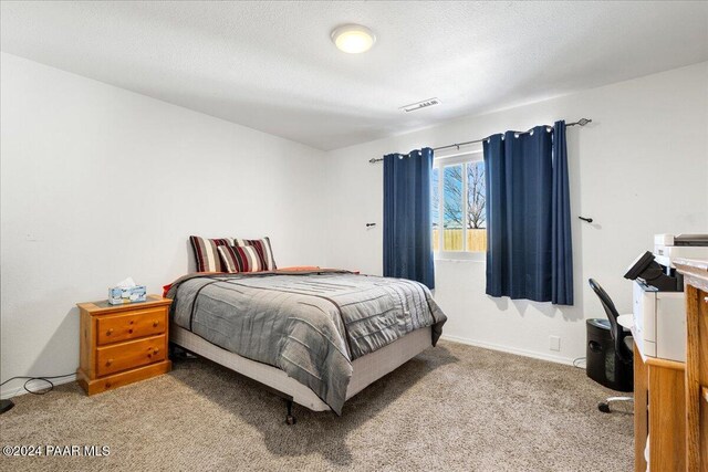 carpeted bedroom featuring a textured ceiling