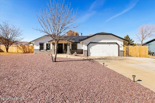 ranch-style house featuring solar panels and a garage