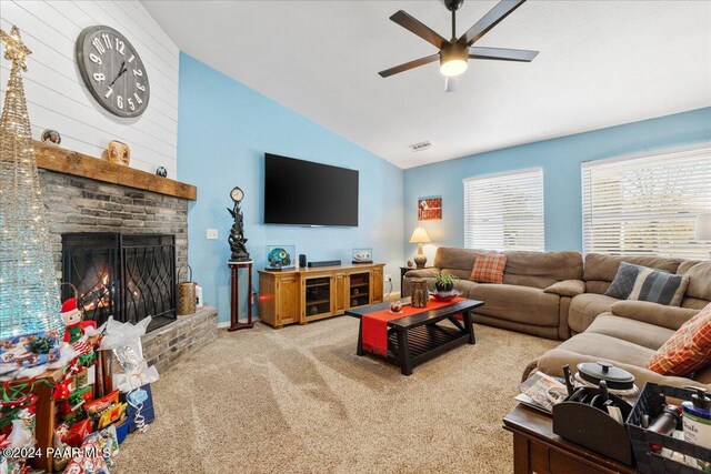 living room featuring carpet flooring, ceiling fan, a fireplace, and vaulted ceiling