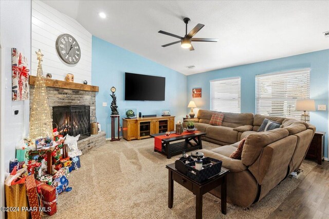 living room featuring hardwood / wood-style flooring, ceiling fan, lofted ceiling, and a brick fireplace