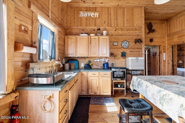 kitchen featuring light brown cabinets, sink, wooden ceiling, dark wood-type flooring, and wooden walls