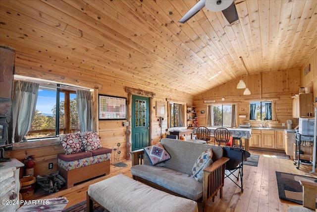 living room with wooden walls, light hardwood / wood-style flooring, vaulted ceiling, ceiling fan, and wood ceiling