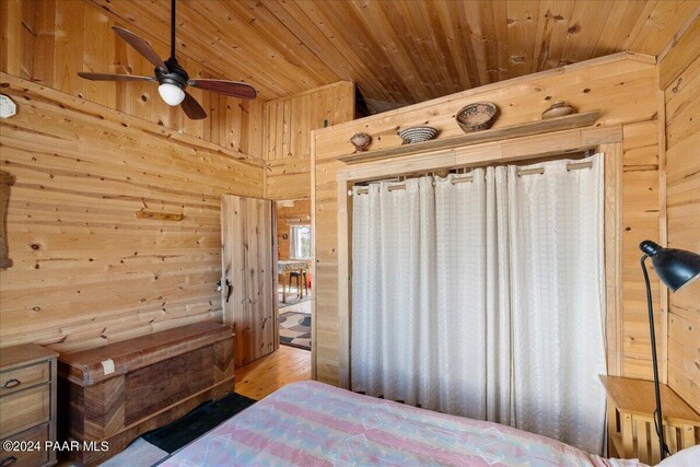 bedroom featuring wood-type flooring, wooden ceiling, and wood walls