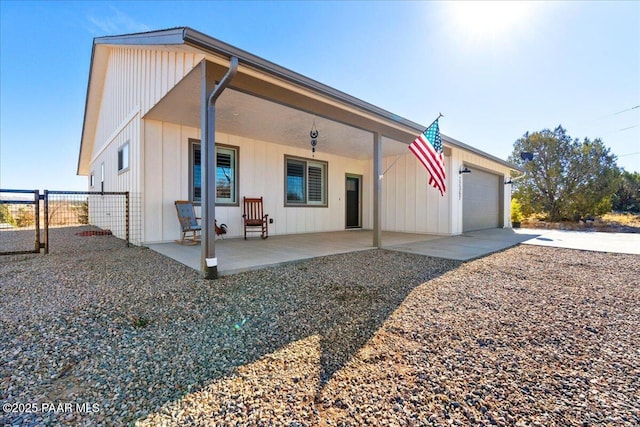 view of front facade with an attached garage, driveway, and fence