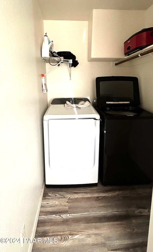 clothes washing area featuring washer and dryer and dark hardwood / wood-style flooring