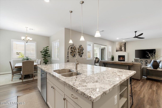 kitchen featuring a sink, ceiling fan with notable chandelier, dark wood-style floors, and a wealth of natural light