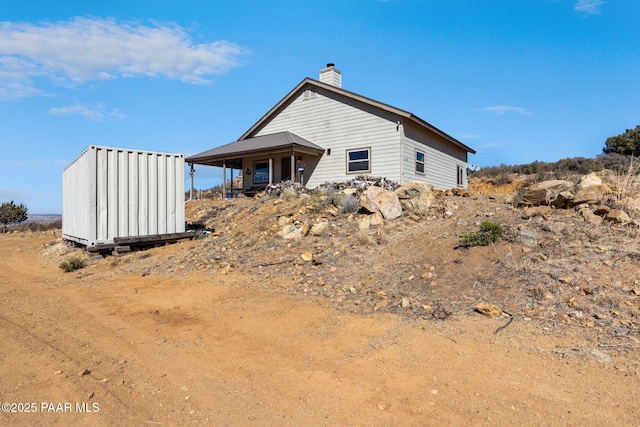 rear view of house featuring a storage shed