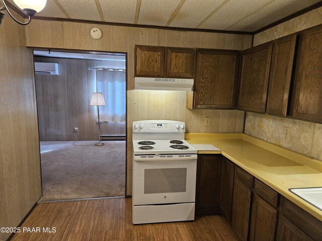 kitchen with white electric range, light hardwood / wood-style flooring, an AC wall unit, and wood walls