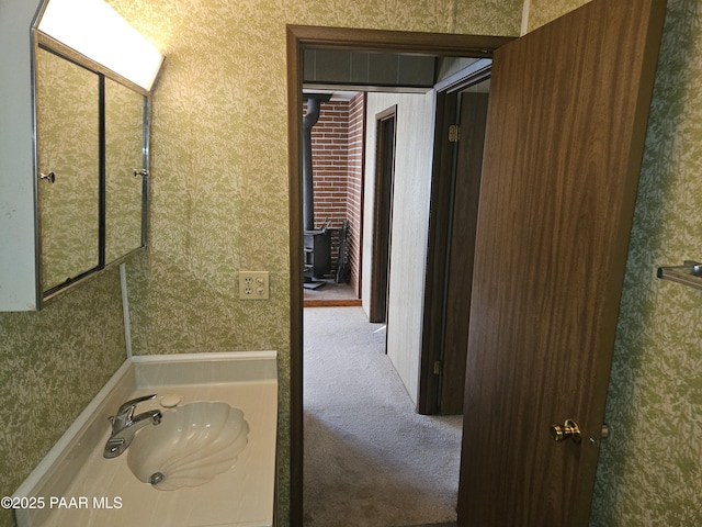 bathroom featuring sink and a wood stove