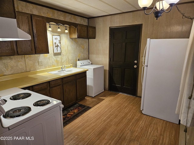 kitchen featuring washer / clothes dryer, white appliances, light hardwood / wood-style floors, and sink