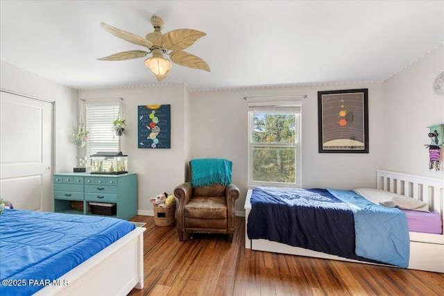 bedroom featuring multiple windows, wood-type flooring, and ceiling fan