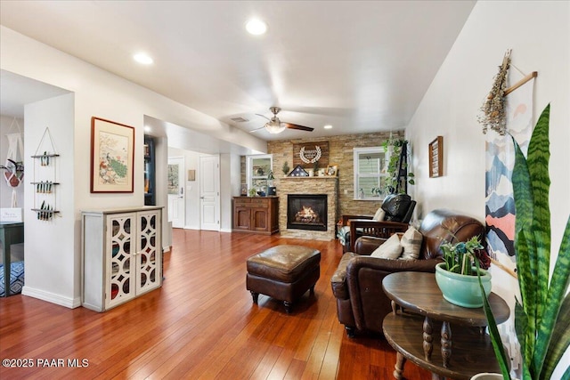 living room with hardwood / wood-style flooring, a fireplace, and ceiling fan