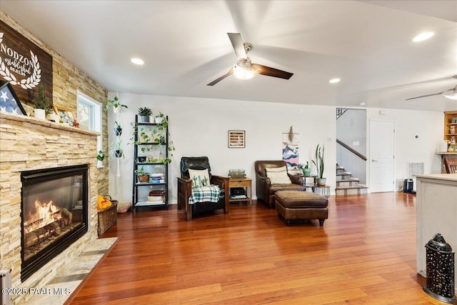 living room with hardwood / wood-style floors, a fireplace, and ceiling fan