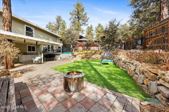 view of patio / terrace featuring a fire pit and a playground