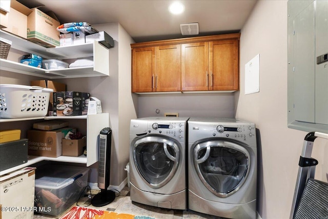 laundry area featuring cabinets, washing machine and clothes dryer, electric panel, and light tile patterned flooring