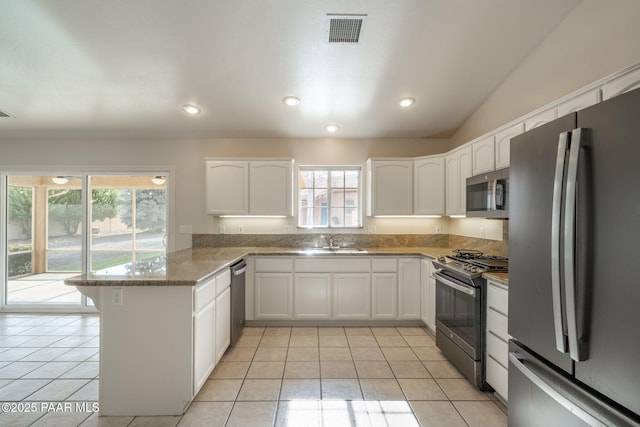 920 Heather Ln, Chino Valley, AZ 86323 - kitchen with stainless steel appliances, a peninsula, a sink, white cabinets, and light tile patterned floors