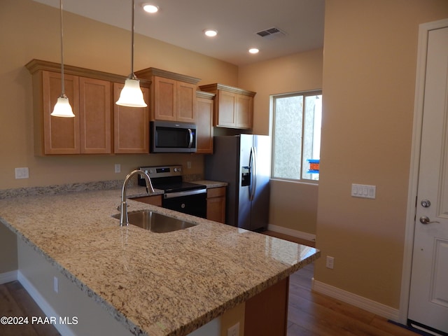 kitchen with decorative light fixtures, kitchen peninsula, and appliances with stainless steel finishes