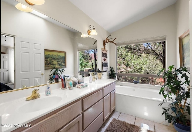 bathroom featuring tile patterned flooring, vanity, vaulted ceiling, and a wealth of natural light