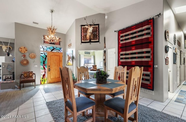 tiled dining room featuring vaulted ceiling and a notable chandelier