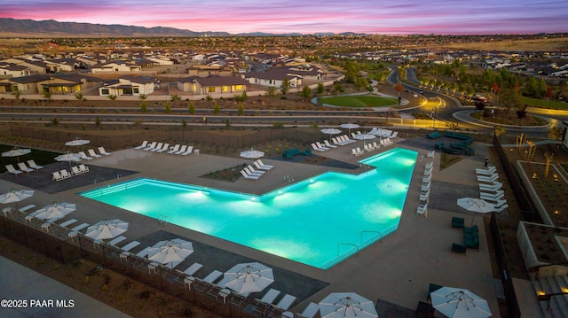 pool at dusk featuring a mountain view and a patio area