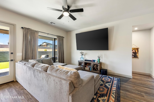 living room with dark hardwood / wood-style floors, a wealth of natural light, and ceiling fan