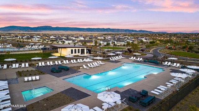 pool at dusk with a mountain view and a patio