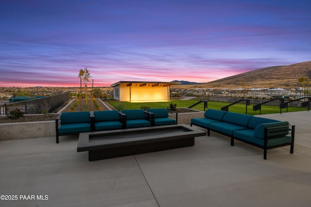 patio terrace at dusk featuring a mountain view and an outdoor hangout area