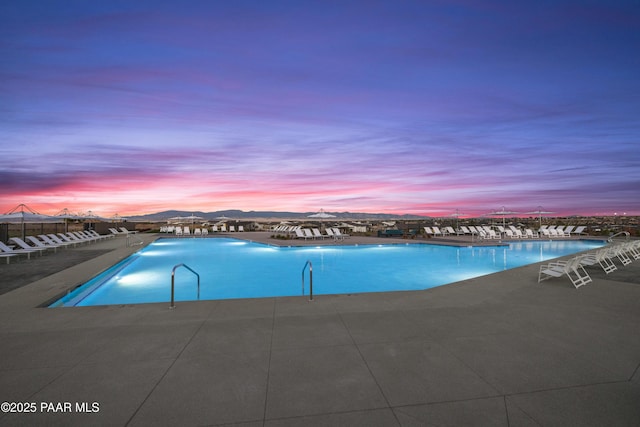 pool at dusk with a patio