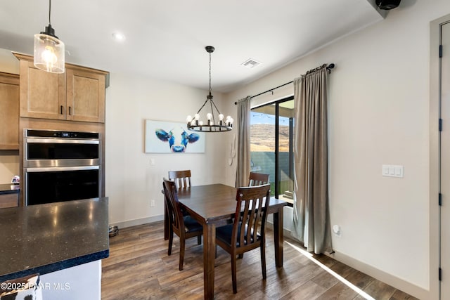 dining area with a notable chandelier and dark hardwood / wood-style floors