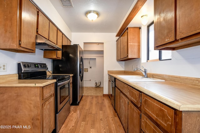 kitchen featuring stainless steel electric range oven, black dishwasher, sink, and light wood-type flooring