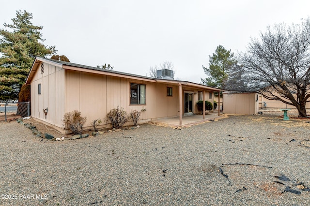 rear view of property with a storage unit, central AC unit, and a patio