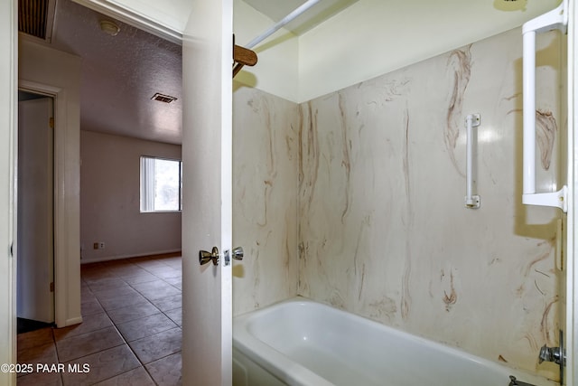 bathroom featuring shower / bathtub combination, tile patterned floors, and a textured ceiling