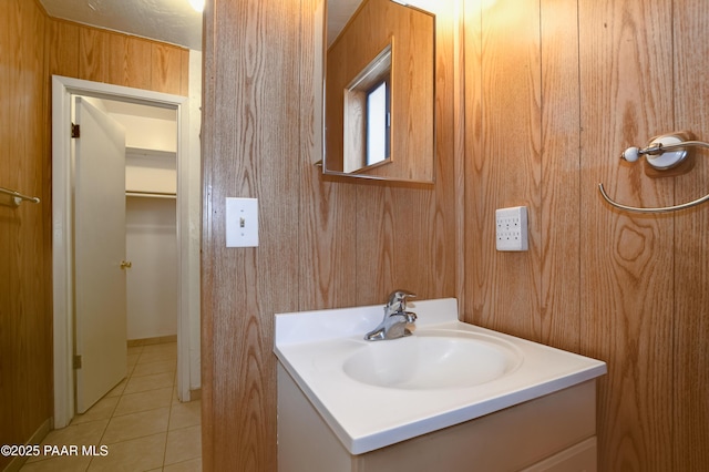 bathroom with tile patterned flooring, vanity, and wood walls