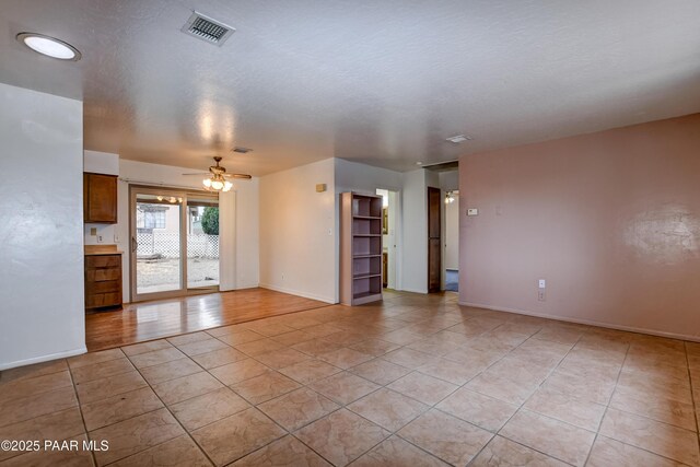 tiled spare room featuring a textured ceiling and ceiling fan